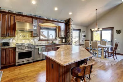 a kitchen with wooden cabinets and a table with chairs at Indian Trail Cabin cabin in Granby