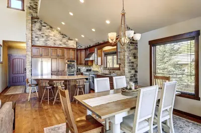 a kitchen and dining room with a wooden table and chairs at Indian Trail Cabin cabin in Granby