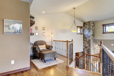 a living room with a chair and a staircase at Indian Trail Cabin cabin in Granby