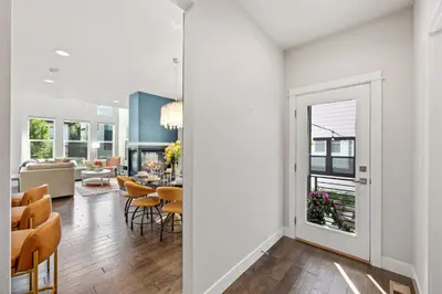 a living room with white walls and a dining room at Upbeat Retreat - Enjoy Bikes, Brews and Mtn Peaks! in Fort Collins
