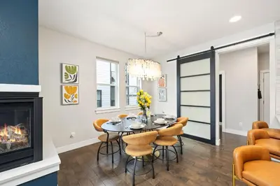 a dining room with a table and chairs and a fireplace at Upbeat Retreat - Enjoy Bikes, Brews and Mtn Peaks! in Fort Collins