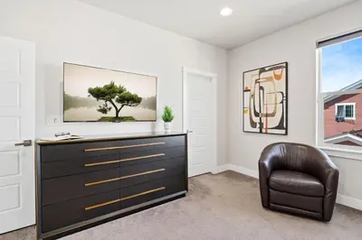 a living room with a dresser and a chair at Upbeat Retreat - Enjoy Bikes, Brews and Mtn Peaks! in Fort Collins