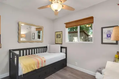 a small bedroom with a bed and a mirror at Old Town Retreat w Vintage Flair Near CSU, Bikes! in Fort Collins