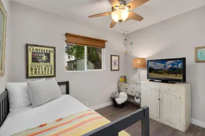 a bedroom with a bed and a flat screen tv at Old Town Retreat w Vintage Flair Near CSU, Bikes! in Fort Collins