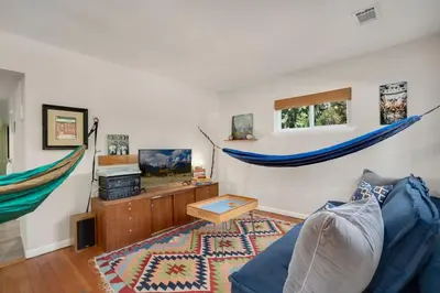 a living room with a blue couch and hammocks at Old Town Retreat w Vintage Flair Near CSU, Bikes! in Fort Collins