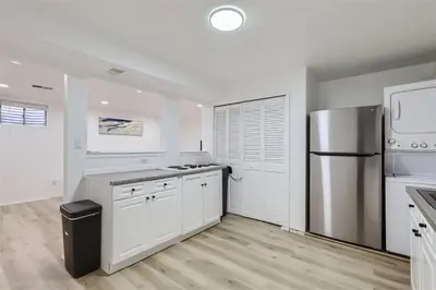 a kitchen with white cabinets and a stainless steel refrigerator at 15-mins from DIA, Fenced-Yard, Garage, Remodeled in Aurora
