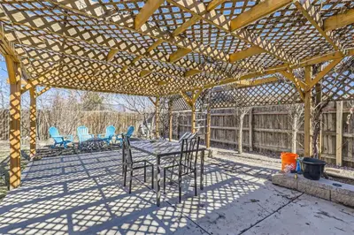 a wooden pergola with chairs and a table on a patio at 15-mins from DIA, Fenced-Yard, Garage, Remodeled in Aurora