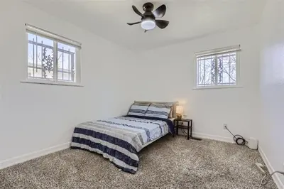 a bedroom with a bed and a ceiling fan at 15-mins from DIA, Fenced-Yard, Garage, Remodeled in Aurora