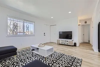 a living room with a couch and a tv at 15-mins from DIA, Fenced-Yard, Garage, Remodeled in Aurora