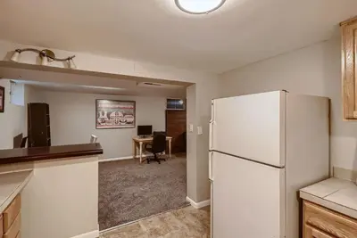 a kitchen with a white refrigerator and a desk at 1000 Dollar Rebate if You Buy A Home in Denver in Lakewood