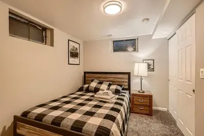 a bedroom with a bed with a checkered blanket at 1000 Dollar Rebate if You Buy A Home in Denver in Lakewood