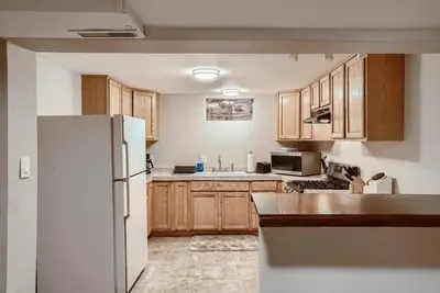 a kitchen with wooden cabinets and a white refrigerator at 1000 Dollar Rebate if You Buy A Home in Denver in Lakewood