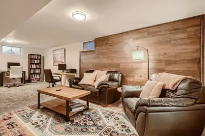 a living room with two leather couches and a table at 1000 Dollar Rebate if You Buy A Home in Denver in Lakewood