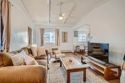 a living room with a couch and a table at 1,000 Per Month Rebate When Buying A Home in Lakewood