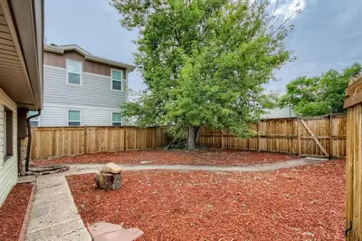 a yard with a fence and a tree at 1,000 Per Month Rebate When Buying A Home in Lakewood