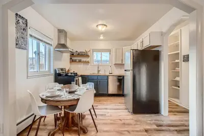 a kitchen with a table and chairs and a refrigerator at 1,000 Per Month Rebate When Buying A Home in Lakewood