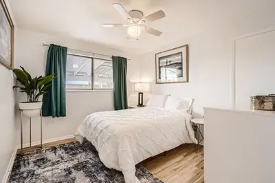 a white bedroom with a bed and a ceiling fan at 1,000 Dollars For Each Month Stayed When Moving to Colorado in Arvada