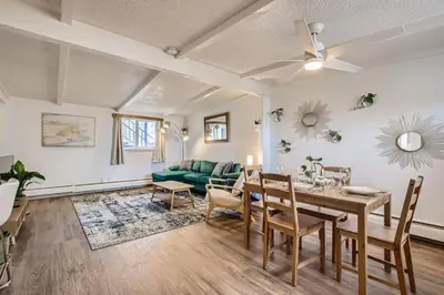 a living room with a table and a couch at 1000 Dollar Rebate if You Buy A Home in Denver in Lakewood