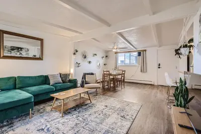 a living room with a green couch and a table at 1000 Dollar Rebate if You Buy A Home in Denver in Lakewood