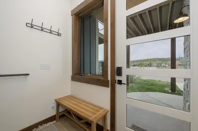 a door to a room with a window and a bench at 90 Hay Meadow townhouse in Fraser
