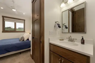 a bathroom with a sink and a mirror and a bed at 90 Hay Meadow townhouse in Fraser
