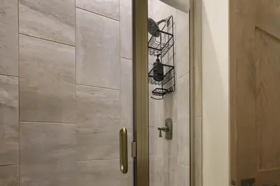 a shower with a glass door with a pair of shoes at 90 Hay Meadow townhouse in Fraser