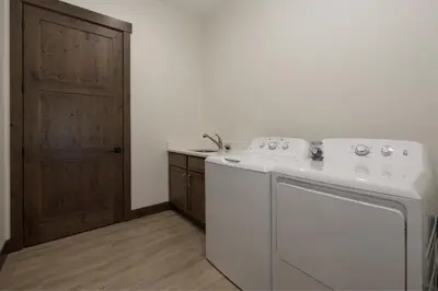 a white washing machine in a kitchen with a door at 90 Hay Meadow townhouse in Fraser