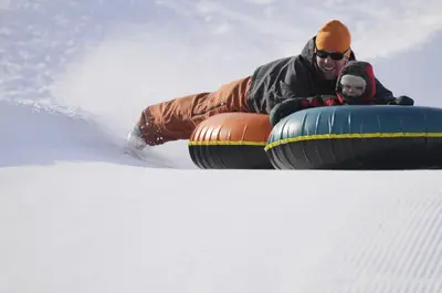 a man riding on a tube in the snow at 90 Hay Meadow townhouse in Fraser