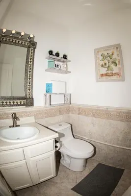 a bathroom with a toilet and a sink and a mirror at InHomeStays in Lakewood