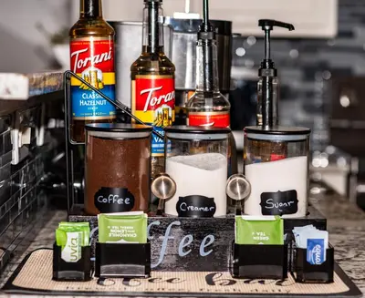 a counter with several bottles of coffee and drinks at InHomeStays in Lakewood