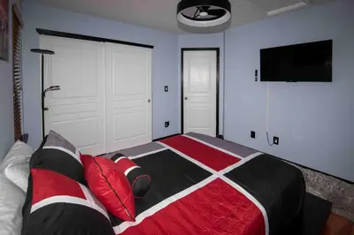 a bedroom with a bed with red and black pillows at InHomeStays in Lakewood