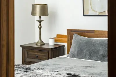 a bedroom with a bed and a lamp on a night stand at Mountain View Apartment Near Downtown & Hiking in Evergreen