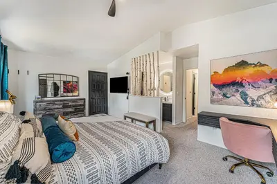 a bedroom with a bed and a desk and a television at All-In-One Retreat Spa, Gym, Fun Room & Location! in Arvada