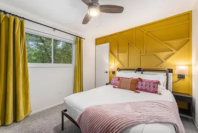 a bedroom with a large bed and yellow curtains at All-In-One Retreat Spa, Gym, Fun Room & Location! in Arvada