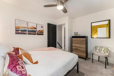 a bedroom with a white bed and a chair at All-In-One Retreat Spa, Gym, Fun Room & Location! in Arvada