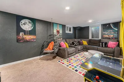 a living room with a couch and a video game at All-In-One Retreat Spa, Gym, Fun Room & Location! in Arvada