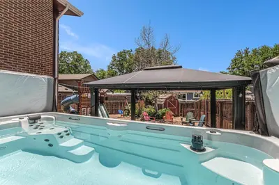 a swimming pool with a table and an umbrella at All-In-One Retreat Spa, Gym, Fun Room & Location! in Arvada