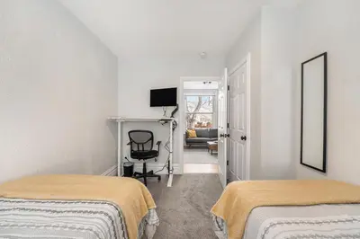a bedroom with two beds and a chair in it at Outdoor Living and comfort by RiNo BBQ Office in Denver