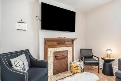 a living room with a fireplace with a tv above it at Outdoor Living and comfort by RiNo BBQ Office in Denver