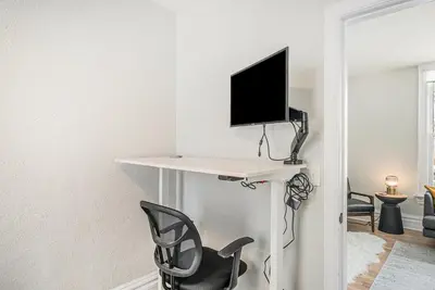 a room with a desk with a tv and a chair at Outdoor Living and comfort by RiNo BBQ Office in Denver