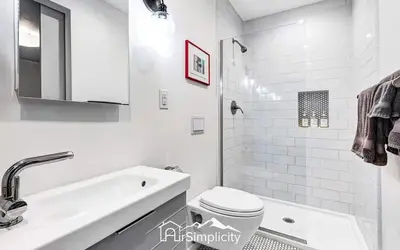 a white bathroom with a toilet and a sink at Sunnyside guesthouse near Rocky Mountain Lake in Denver
