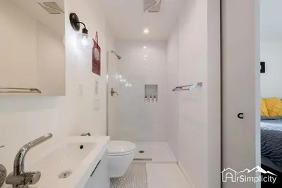 a white bathroom with a toilet and a sink at Sunnyside guesthouse near Rocky Mountain Lake in Denver