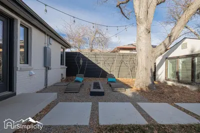 a yard with a tree and steps next to a building at Sunnyside guesthouse near Rocky Mountain Lake in Denver