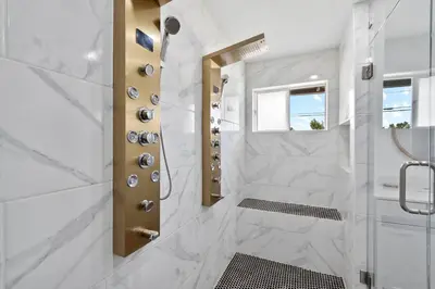 a bathroom with a shower with white marble at Modern Family Home Rooftop Patio Game Room in Denver