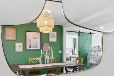 a mirror reflecting a dining room with a table and chairs at Modern Family Home Rooftop Patio Game Room in Denver