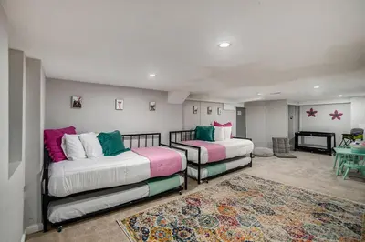 a living room with two beds and a rug at Modern Family Home Rooftop Patio Game Room in Denver