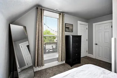 a bedroom with a bed and a mirror and a window at Work-Friendly Denver Stay - Rooftop Deck & Garden in Denver