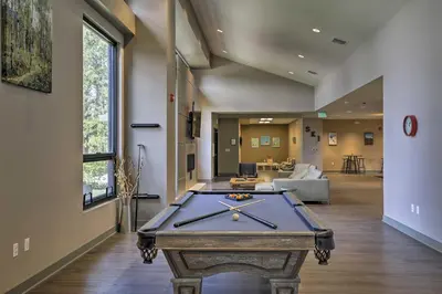 a pool table in the middle of a living room at Riverside Condo in Downtown Winter Park! in Winter Park