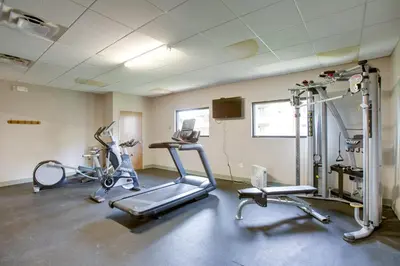 a gym with two exercise bikes and a treadmill at Riverside Condo in Downtown Winter Park! in Winter Park