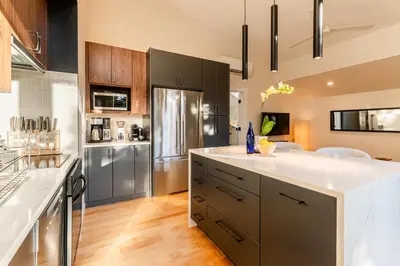 a kitchen with a large white counter top and a refrigerator at 30-Day Minimum Boulder Bright & Modern Private 1BR 2BA ADU in Boulder